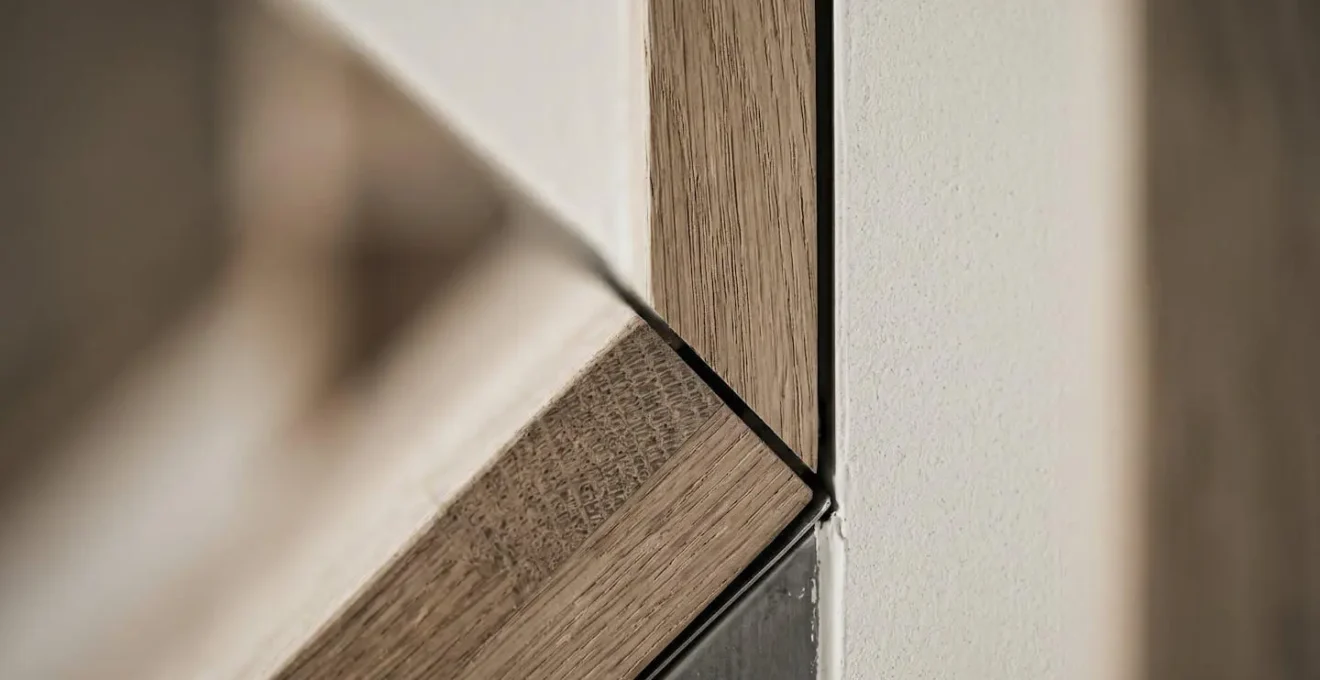 Gros plan sur un détail architectural de jonction entre éléments de construction, illustrant l'importance des finitions pour l'étanchéité à l'air