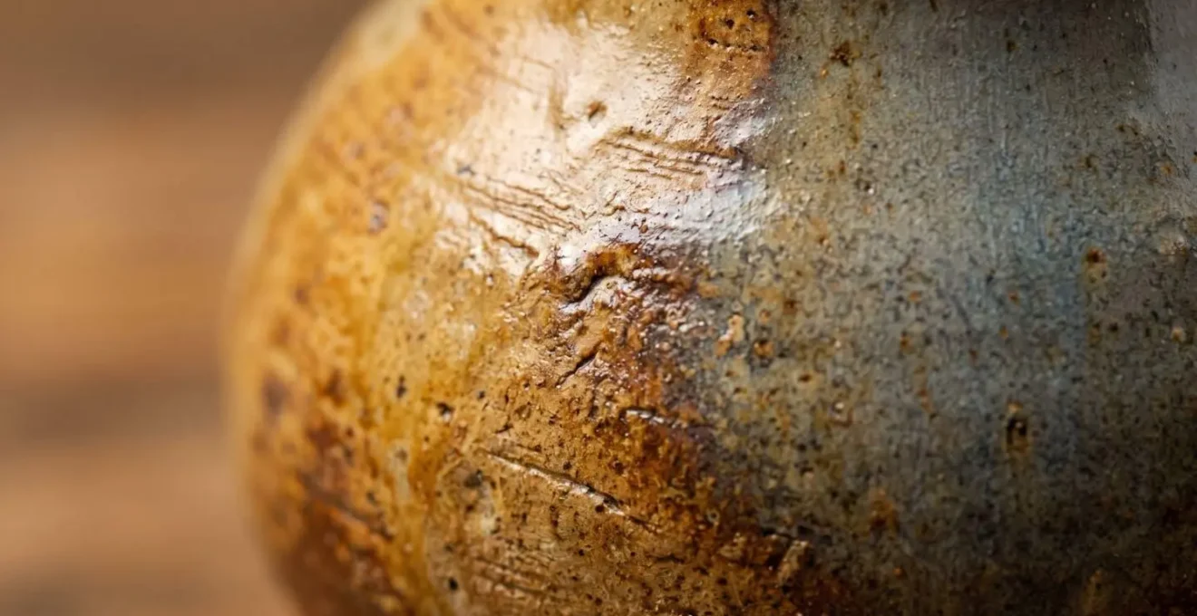 Gros plan macro sur détails texturés d'une céramique artisanale française avec palette naturelle