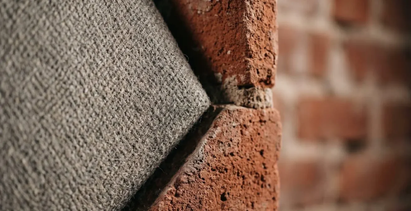 Panneaux acoustiques texturés intégrés comme éléments décoratifs sur mur de briques dans un loft pour réduire la réverbération